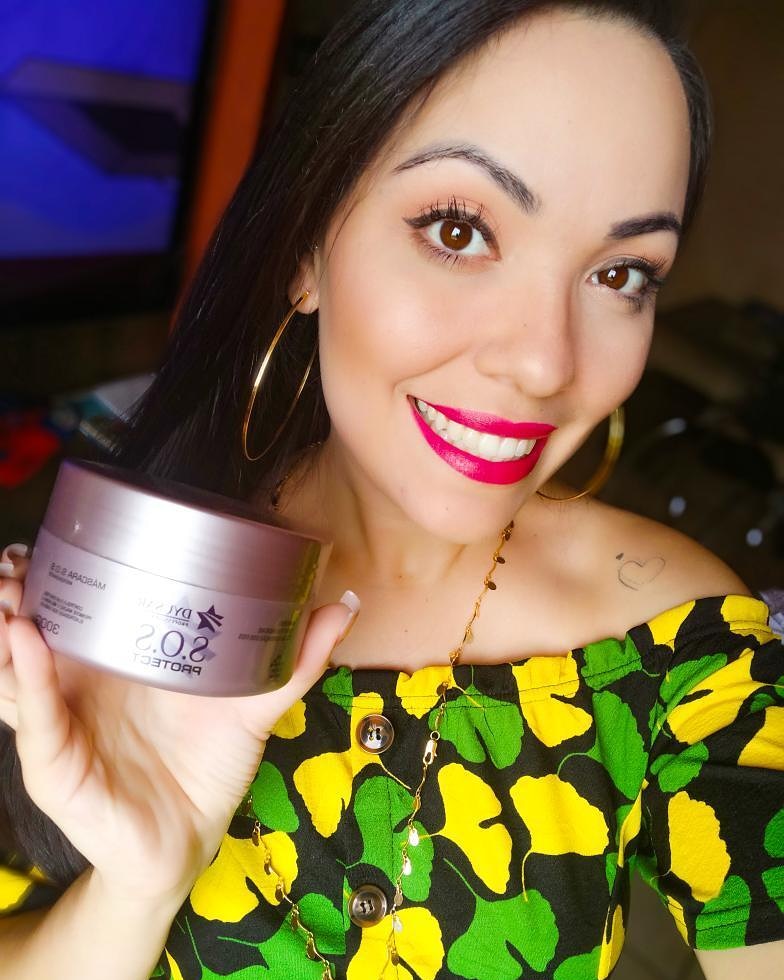 Modelo sorrindo mostrando a Máscara S.O.S Protect (300g), a etapa de Nutrição do Kit Cronograma Capilar.