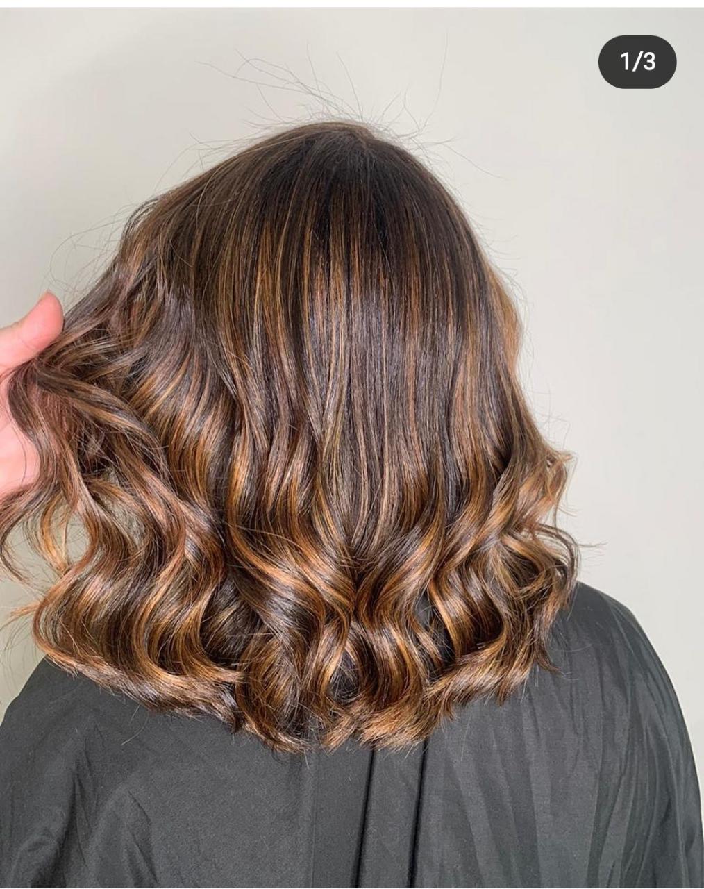 Cabelo estilo long bob ondulado e morena iluminada, com brilho e cor vibrante após tratamento com a Máscara Antioxidante S.O.S Protect.