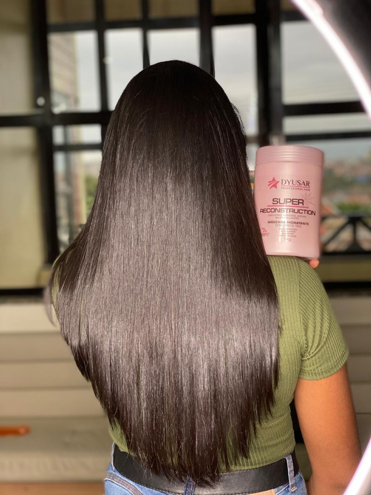Mulher de costas com cabelo liso e brilhante, mostrando o resultado do kit de cauterizacao profissional para salao da Dyusar