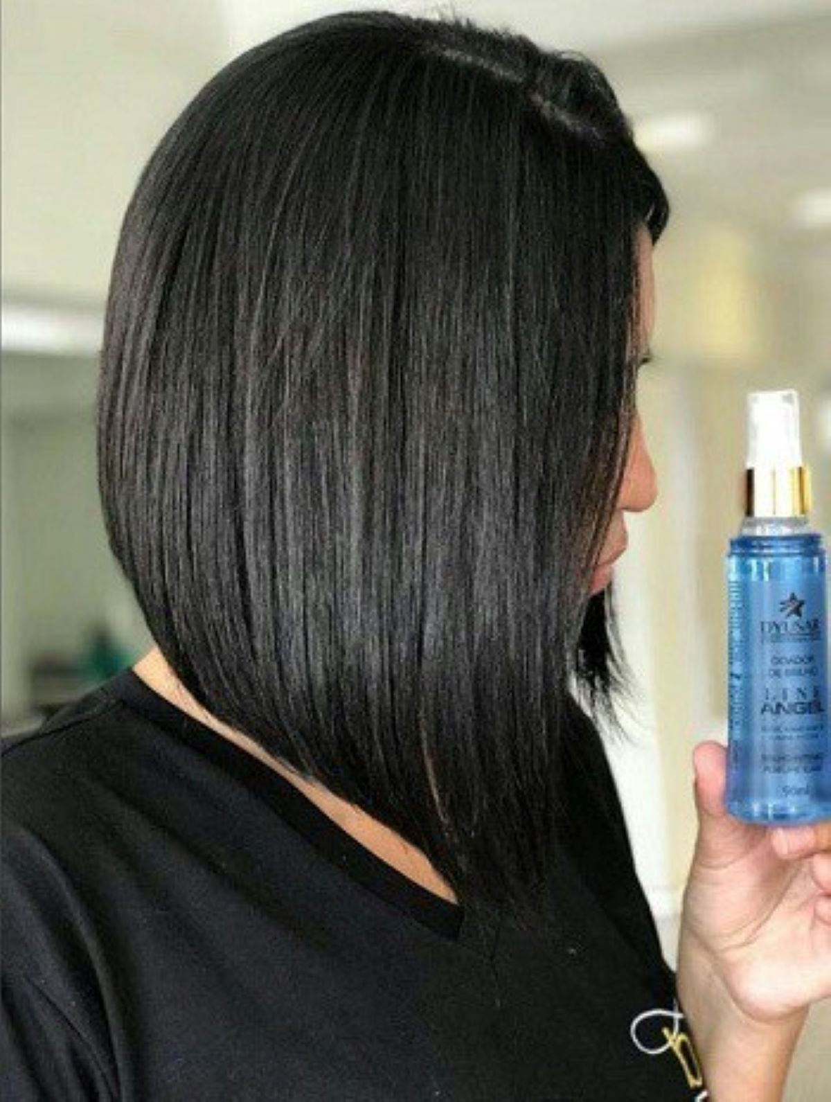 Mulher com cabelo preto e corte chanel de bico, mostrando o resultado de brilho após usar o Spray de Brilho e Perfume Capilar Line Angel.