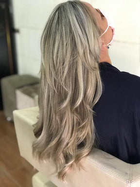 Resultado de um cabelo longo e repicado em tom loiro acinzentado claro, mostrando a cor e o brilho obtidos com a Coloração Louro Muito Claro Acinzentado 9.1.
