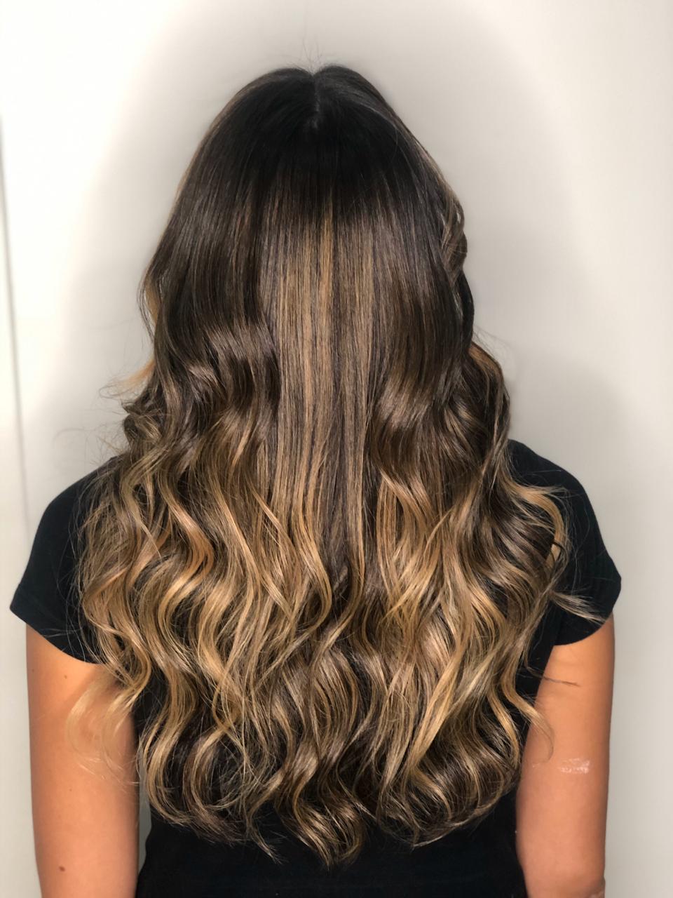 Resultado de cabelo saudável e brilhante em uma mulher morena iluminada, mostrando o efeito de preparação e limpeza do Shampoo Detox antes da coloração.