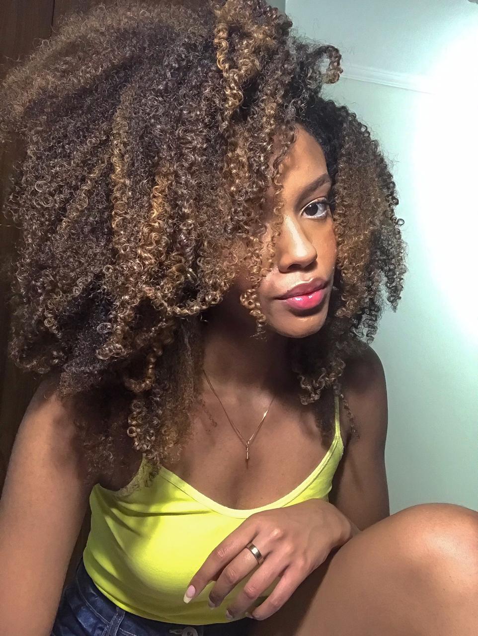 Close-up de uma mulher com cabelo crespo volumoso e com luzes, mostrando a definição e o volume obtidos com o tratamento da linha Perfect Curly, que inclui o Shampoo para Cabelos Cacheados.