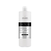 Frasco de 500ml do Shampoo Detox profissional da Dyusar, com rótulo preto e branco destacando sua função de remover metais pesados e os ingredientes Glicoamine e Ionene.