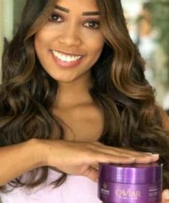 Modelo com cabelo perfeito e segurando o pote da Máscara de Nutrição Caviar Care da DYUSAR Cosméticos utilizado em sua hidratação