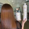 Mulher mostrando o cabelo enquanto segura o produto.