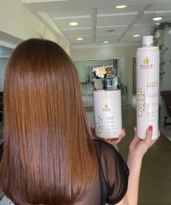 Mulher mostrando o cabelo enquanto segura o produto.