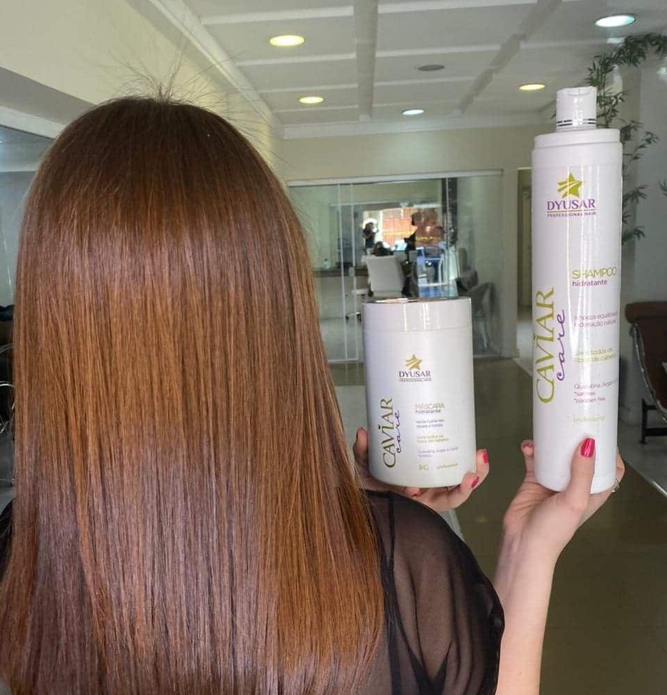 Mulher mostrando o cabelo enquanto segura o produto.