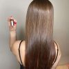 Cabelo castanho cheio de brilho e maciez após o uso de uma das ampolas do kit de cronograma capilar da DYUSAR